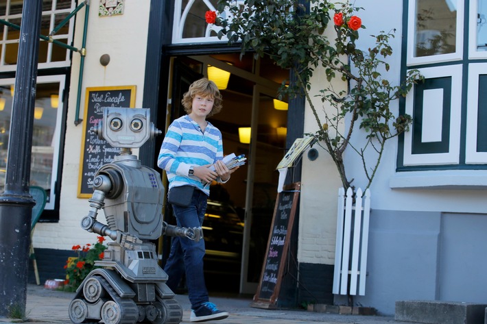 Tobbi (Arsseni Bultmann) zeigt seinem neuen Freund, Roboter Robbi, seinen Heimatort Tütermoor. Nutzung des Bildes nur in Verbindung mit der Sendung / kein Social Media Weiterer Text über ots und www.presseportal.de/nr/7840 / Die Verwendung dieses Bildes ist für redaktionelle Zwecke honorarfrei. Veröffentlichung bitte unter Quellenangabe: