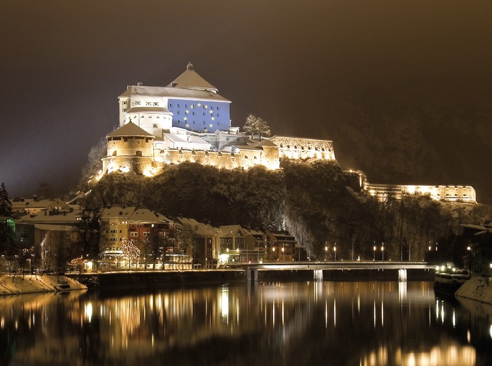 Kufstein, die Perle am grünen Inn, ist historisch eng mit dem angrenzenden Bayern verbunden. Die Festung Kufstein war Jahrhunderte lang das Objekt der Begierde zahlreicher Grenzstreitigkeiten. Das Kufsteinerland wurde erst 1814 dauerhaft Tirol zugesprochen.
In Kufstein selbst wird ein freundschaftliches Verhältnis zum deutschen Nachbarn gelebt, und besonders jetzt in der Zeit der Grenzschließungen und Ausgangssperren merkt man auf beiden Seiten der Grenze, wie sehr diese Verbindung nun fehlt.
Aus diesem Grund setzt Kufstein ein leuchtendes Zeichen ? am 7. Mai um 21 Uhr wird auf die Festung die EU-Flagge projektiert. Die Festung Kufstein selbst öffnet am 30. Mai 2020 wieder ihre Pforten für Besucher.
Die Sterne des EU-Emblems stehen für die Zusammengehörigkeit, die für die Kufsteiner Bevölkerung, den Handel und nicht zuletzt den Tourismus integraler Bestandteil des täglichen Lebens war und ist. Mit Corona wurde die so gewohnte Reisefreiheit abrupt verändert ? plötzlich wurde angehalten, kontrolliert und auch gestraft. Für das offene und gesellige Volk des Kufsteinerlandes und seine Nachbarn ein herber Schlag.Lena Maier aus Erl erzählt: ?Wer direkt an der Grenze wohnt wie wir, lebt eigentlich auf beiden Seiten. Die Grenze existierte für uns immer nur theoretisch und jeder hat Freunde, Verwandte auf der ?anderen Seite?. Normalerweise besuche ich meine beste Freundin in Oberaudorf mit dem Rad und nehme einfach die Holzbrücke über den Inn. Von einem Tag auf den anderen war der Übergang mit einem Holzverschlag dichtgemacht. Ein eigenartiges Gefühl sich nicht mehr nah sein zu können.?Erl liegt direkt an der Grenze und am Kranzhorn steht man mit einem Bein auf deutschem und mit dem anderen auf österreichischem Boden. So wie Lena geht es vielen im Kufsteinerland. Durch die Grenzschließung wurde so manc...