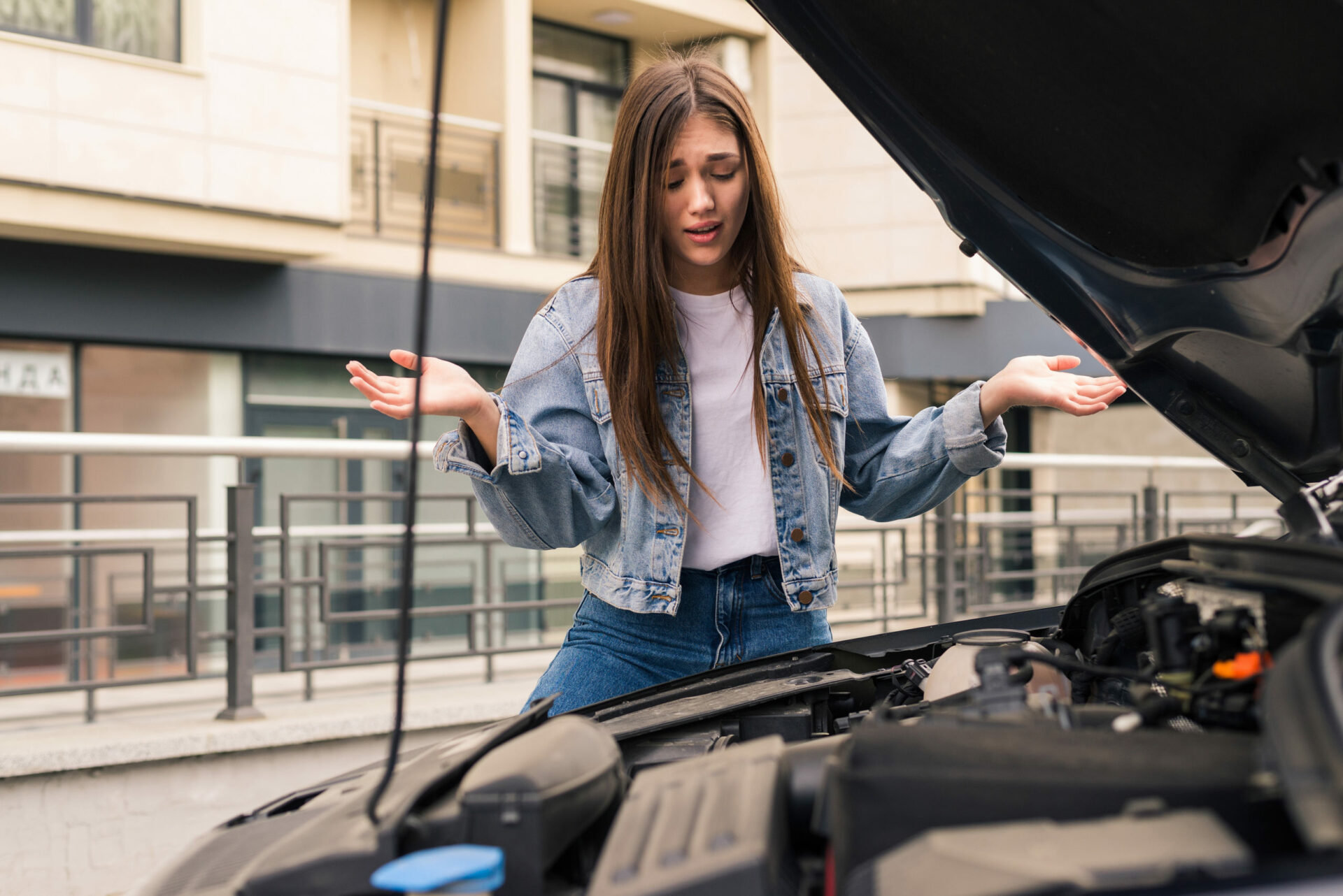 Young worried girl of the mechanic the problem with a car